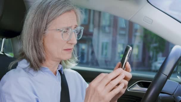 スマートフォンで悪いニュースを受け取る中年女性の動揺 車のローンの放棄 — ストック動画