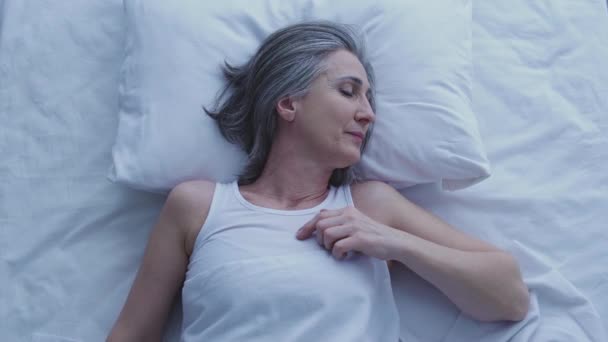 成年灰发女子辛苦劳作一天后 躺在舒适的床上休息 — 图库视频影像