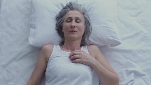 熟れた白髪の女性は 睡眠中に凍結感じます 悪い睡眠条件 — ストック動画