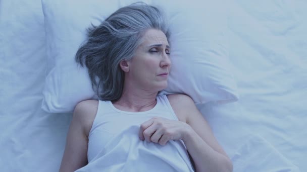 Κουρασμένη Δυστυχισμένη Ηλικιωμένη Γυναίκα Ξαπλωμένη Στο Κρεβάτι Προσπαθώντας Κοιμηθεί Υποφέρει — Αρχείο Βίντεο