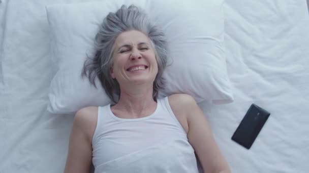 非常に幸せな陽気な女性のベッドで 朝を楽しんで横たわっ笑顔 トップビュー — ストック動画