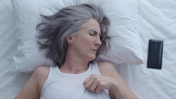 Yetişkin Bir Uykucu Kadın Akıllı Telefondan Saate Bakıyor Battaniyenin Altında — Stok video