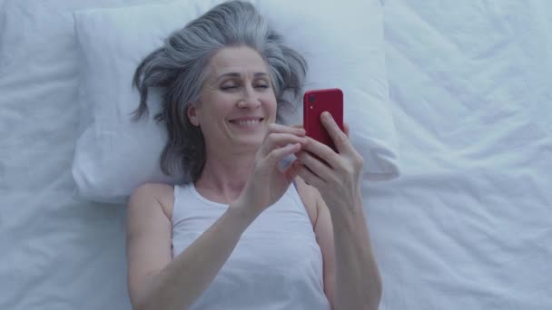 幸せな成熟した女性の笑顔 夜に電話でメッセージを読む オンライン浮気 — ストック動画