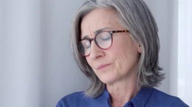 Gergin bir kadın, endişeli bir şekilde pencereye bakan kocasını bekliyor.