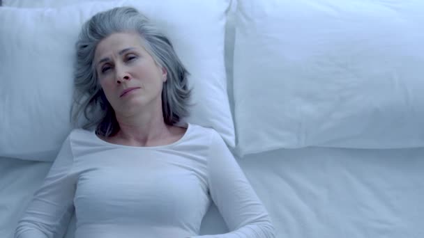 毛布で覆われた思慮深い白髪の女性 ベッドで寝て 不眠症 — ストック動画