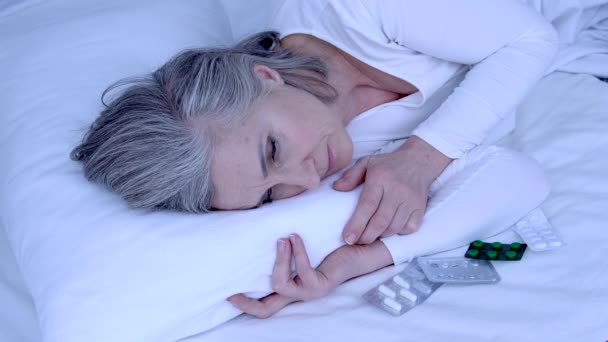 Hasta Yaşlı Kadın Yatakta Yatıyor Yastığının Yanında Bir Sürü Hap — Stok video
