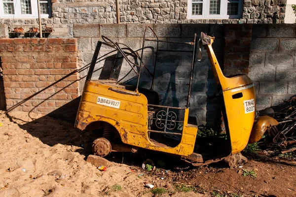 terk edilmiş riksha Hindistan 'da bir duvarın önünde.