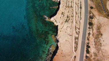 Kıbrıs 'tan 4K drone videosu. Deniz ve kıyı şeridi kristal berrak su ve kayalarla