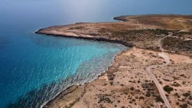 Kristal berrak su ve kayalarla denizin drone videosunu göster