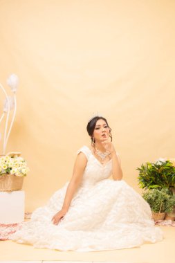 Zarif bir kadın poz verir, rahat rahat rahat oturur, merdivenleri seyreder, ağzının içine bakar, güzel bir elbise giyip fotoğraf çektirir. Evlilik Ulusal Gelin Stüdyosu