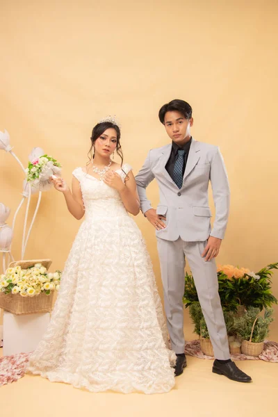 elegant expression male and female couple in formal poses standing relaxed smiling looking at each other intimately indoor photo shot. couple wedding national bride studio