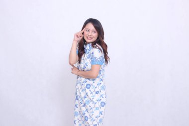 Güzel, neşeli Çinli kadın modern Çin elbisesi giymiş beyaz arka planda bırakılmış şarkı sözleri işaretli. Mutlu Çin Yeni Yılı