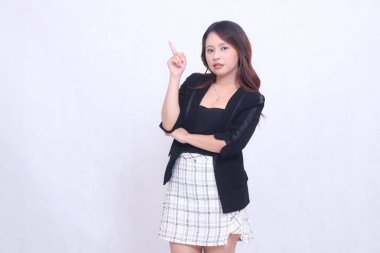 20 'li yaşlarda genç bir Asyalı kadın, resmi bir ofis, zarif, kollarını kavuşturmuş, sol üst tarafı işaret ediyor, beyaz bir arka planı var. Çin mutlu yıllar.