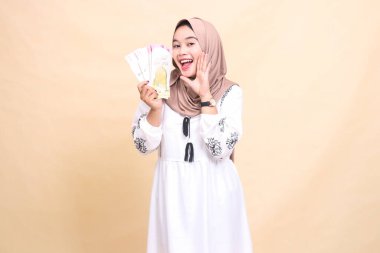 Güzel bir Asyalı Müslüman kadının portresi tesettürlü, neşeli bir şekilde gülümseyen, bayramda hediyeler ve hediyelerle hava atan. Reklam, hediye ve Ramazan için kullanılır.