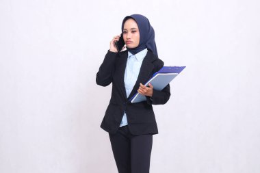 Özel tesettürlü Asyalı ofis kızı insanları aramaktan, kalem, not defteri ve not defteri taşımaktan hayal kırıklığına uğradı. Mavi gömlekli güzel Müslüman kadın.