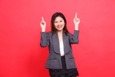 İki eli havada, gri ceketli ve kırmızı arka planda siyah etekli mutlu bir Asyalı ofis kızı jesti. kurumsal kavramlar, yayınlar ve reklamlar için