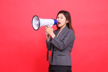 Asyalı ofis kadınının yüzü sağa doğru eğildi ve kameraya megafonla gri ceket ve kırmızı etek giyiyordu. Yayın, iş ve reklam kavramları için