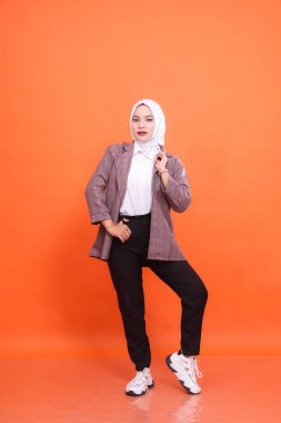 Beyaz ofis elbisesi giyen güzel Asyalı kız modelin tam boy portresi izole edilmiş turuncu stüdyo arka planı giyer. Moda kavramı, güzellik, arkadaşlık