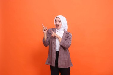 Büyük girişimci konsepti. Asyalı iş kadını sol üstteki kapalı alanda izole edilmiş turuncu stüdyonun el işaretini şok etti. İş, finans ve reklamcılık