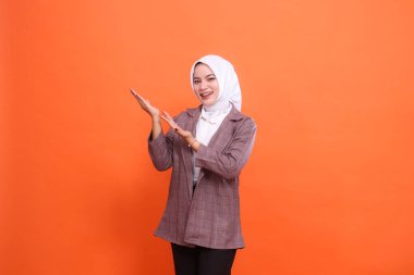 Büyük girişimci konsepti. İki avuç içi yukarı bakan neşeli Asyalı iş kadını kapalı alanda izole edilmiş turuncu arka plan sunuyor. İş, finans ve reklamcılık