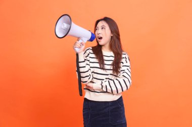 Asyalı kadın kollarını tutarken anons etmek için megafon hoparlörünü tutarak haykırıyor. moda, iş ve yayın kavramları için