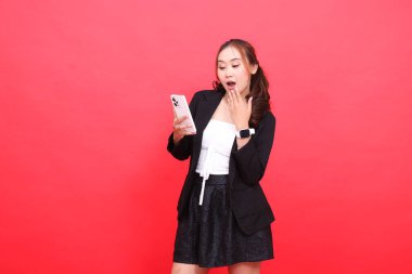 Endonezya 'daki olgun bir kadının jesti siyah takım elbiseli bir kadının teknoloji, iş dünyası, reklamcılık ve finansal içerik için akıllı telefon kullanmasını şok etti.