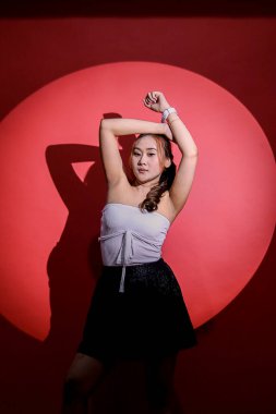 Güzel, genç, Asyalı, seksi, zarif bir ofis. Siyah, resmi bir takım elbise giyiyorlar. Moda içeriği, promosyonlar, reklamlar için spot ışığı konseptiyle üst üste dizilmiş.