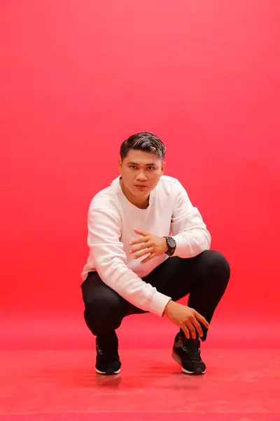 stock image Full body, adult Asian boy wearing an elegant white sweater, squatting cool. for fashion content, advertising, business