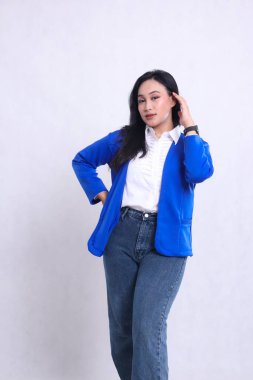 Endonezya 'nın genç ve güzel ofis hanımı mavi resmi bir takım elbise giyiyor zarif bir şekilde duruyor, saçını tarıyor ve belini tutuyor. Şirket, güzellik ve iş içeriği için