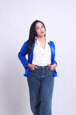 Güzel genç Asyalı seksi ofis kadını resmi mavi takım elbise giyiyor ve elleri pantolonun cebinde zarif duruyor. Şirket, güzellik ve iş içeriği için