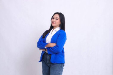 Mavi bir takım elbise giyen, sağa doğru eğri büğrü duran ve kolları bağlı gülümseyen güzel bir Asyalı ofis kadınının cazibesi. şirket, güzellik, iş, mali ve promosyon için