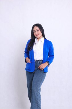 Endonezya 'nın genç ve güzel ofis hanımı resmi mavi takım elbise giyiyor ve elleri ceketin cebinde zarif bir şekilde duruyor. Şirket, güzellik ve iş içeriği için