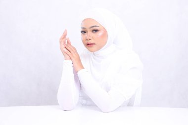 Peçeli kız Endonezyası 'nın güzelliği kameraya odaklanıyor. Mükemmel ve sağlıklı beyaz tenli, iki eli de izole edilmiş beyaz arka planda. Cilt bakımı, sağlık ve bakım için makyajlı kızın yüzü