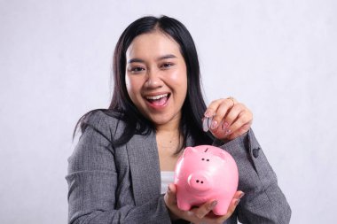 Güzel ofis hanımı Asia 'ya yakın plan. Beyaz arka planda izole edilmiş, yaşlılık birikimleri için para ve kumbaralar taşıyor. reklam, eğitim, güvenli para, yaşam tarzı