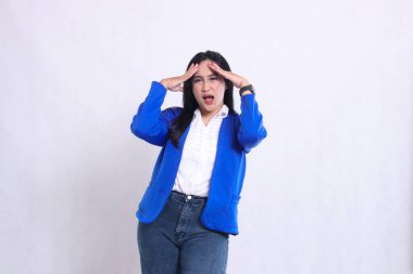 Resmi takım elbise giyen, kameraya doğru haykıran, başı dönen, iki eliyle başını tutan güzel bir ofis kadınının ifadesi. şirket içeriği, sağlık, iş, bakım, yaşam tarzı