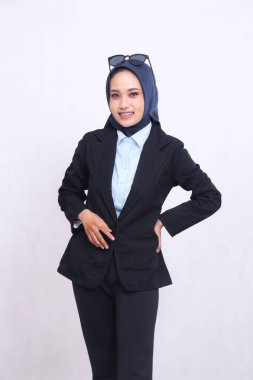 Resmi Asyalı ofis kadını mavi gömlekli tesettürlü kamera karşısında gülümseyen elleri belinde ve düğmelerini ilikle. Güzel Müslüman kadınlar iş, finans ve moda içeriğini kullanır