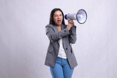 Güzel, genç bir ofis çalışanı iki eli de megafon hoparlörlü, beyaz arka planda izole edilmiş gri takım elbiseli öfkeli bir şekilde bağırıyordu. moda konsepti, reklamcılık, duyuru, indirim
