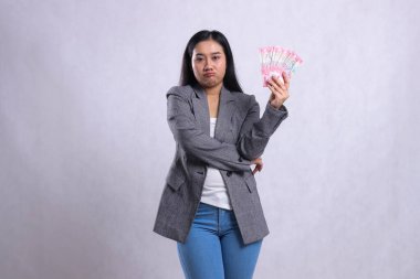 Beyaz arka planda izole edilmiş gri takım elbiseli güzel ofis kızı Asya 'nın somurtması. hediye içeriği, yaşam tarzı, ödül, etkinlik, yarışma