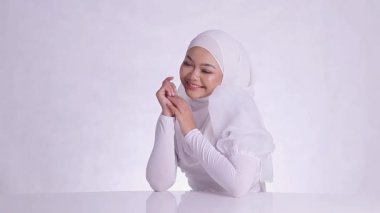 Peçeli kadının mükemmel ve sağlıklı beyaz teniyle kameraya gülüşünün güzelliği, iki eli de sol yanağına dokunuyor izole beyaz arka plan. yüz makyajı, cilt bakımı, sağlık, bakım içeriği