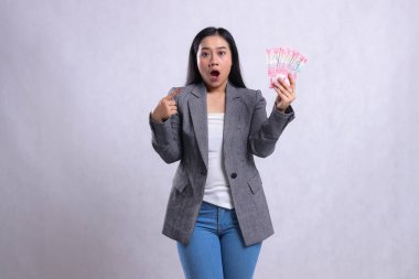 Beyaz arka planda izole edilmiş gri takım elbise giyen genç ve güzel ofis hanımlarının el işaretleri ve rupiah parası. hediye içeriği, yaşam tarzı, ödül, etkinlik, yarışma