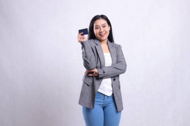 Güzel, genç ofis hanımları, beyaz arka planda tek başına duran gri takım elbiseli, bankamatik kartı tutan samimi gülümseme kolları taşıyorlar. şirket, yaşam tarzı, finans, işlem içeriği