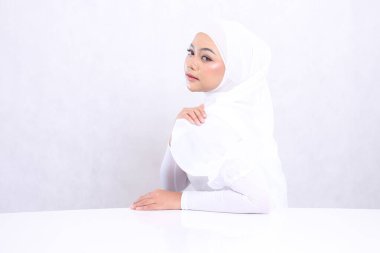 Yandan portre güzel genç kız Asia tesettür kamera elleri keskin beyaz masa ve omuz, doğal makyaj Korea, Tayland izole beyaz arka plan. konsept Yüz tedavisi