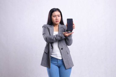 Genç ve güzel ofis hanımları Asia 'nın cep telefonu sunumuna kızması beyaz arka planda izole edilmiş gri takım elbise giymiş cep telefonu ekranını gösteriyor. Teknoloji, yaşam tarzı ve tanıtım içeriği için