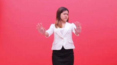 Beyaz ofis kıyafeti giyen güzel Asyalı kız hayır ve reddediyor. Terfi, eğitim ve reklam için kırmızı arka planda duruyor.