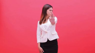 Beyaz takım elbiseli kız kollarını çapraz işareti ile somurtuyor. Terfi, eğitim ve reklam için kırmızı arka planda duruyor.