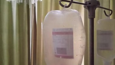 Hasta ve infüzyon pompası için hastane koğuşunda odası ve ışık geçmişi olan serum fizyolojik solüsyon serumunu kapatın. Sağlık, eğitim ve bilim içeriği için