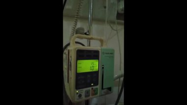 Hasta ve infüzyon pompası için hastane koğuşunda odası ve ışık geçmişi olan serum fizyolojik solüsyon serumunu kapatın. Sağlık, eğitim ve bilim içeriği için