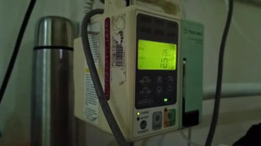 Hasta ve infüzyon pompası için hastane koğuşunda odası ve ışık geçmişi olan serum fizyolojik solüsyon serumunu kapatın. Sağlık, eğitim ve bilim içeriği için