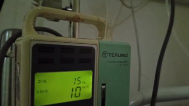 Hasta ve infüzyon pompası için hastane koğuşunda odası ve ışık geçmişi olan serum fizyolojik solüsyon serumunu kapatın. Sağlık, eğitim ve bilim içeriği için