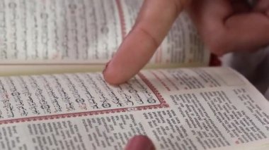 Bir insanın parmağı, açık-seçik Arapça bir Kitap 'la Arapça bir Kitap' ı işaret eder. yeşil arkaplanda ya da yeşil ekranda izole edilmiş